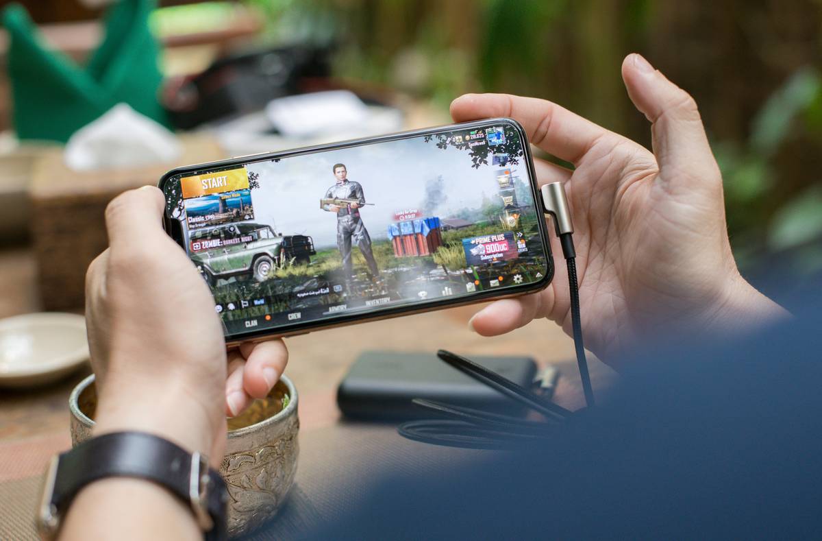 Group of adults laughing while playing mobile games at an entertainment ideas for adults party