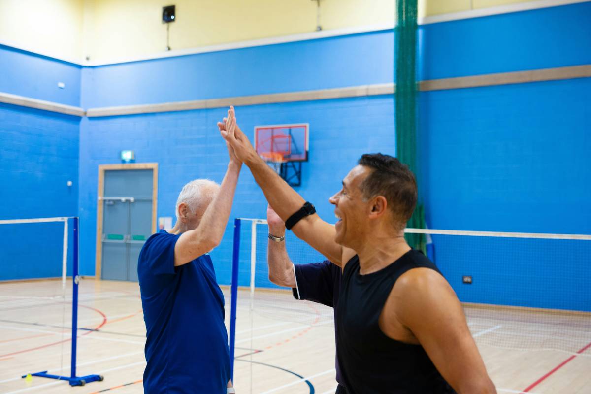 fun exercise activities for adults showing a person stretching while holding a smartphone