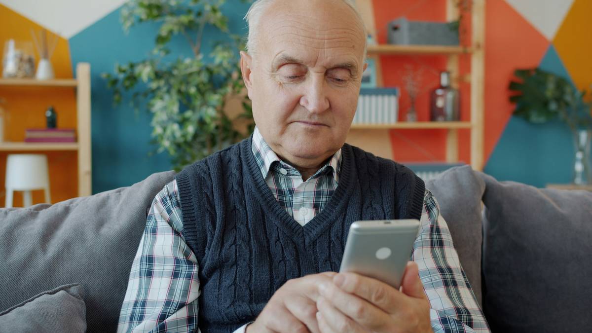 Senior woman smiling while playing puzzle game on tablet, demonstrating gaming for older adults